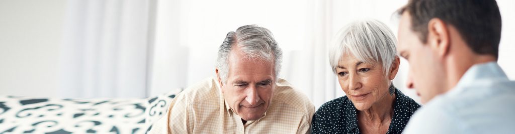 Young man talking to two elderly people