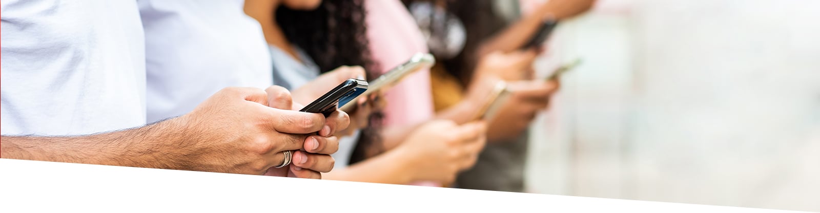 People standing looking at their mobile phones