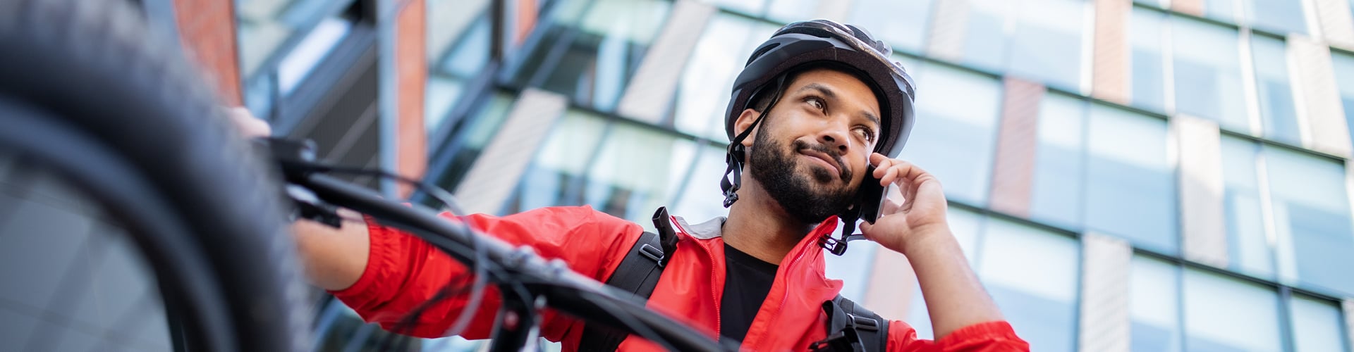 Man on phone standing with bicycle