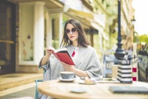 Lady reading book drinking a coffee