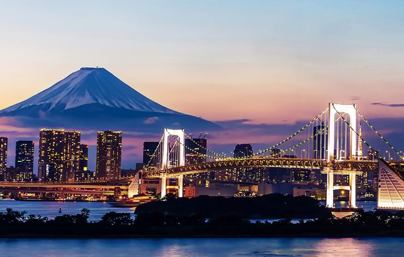 Bridge and office blocks at sunset in Japan with Mount Fuji backdrop