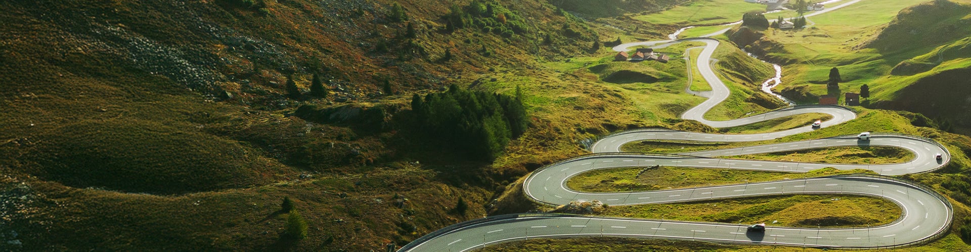 View over winding road through countryside with cars