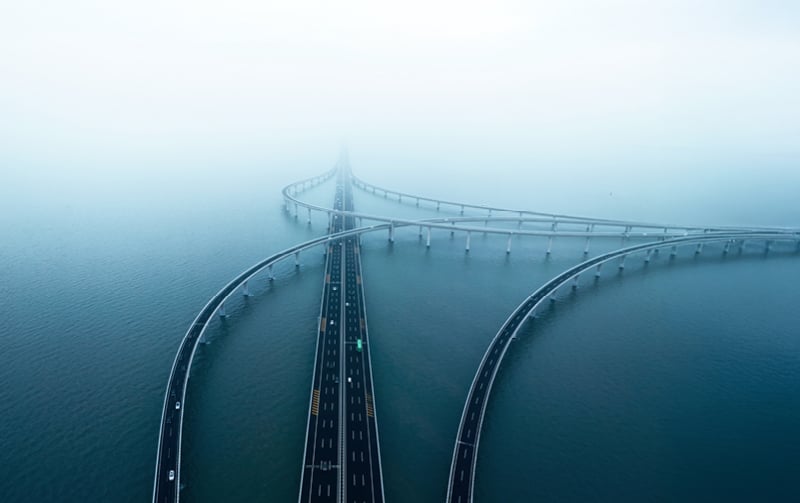 Interconnected bridges over water under misty sky