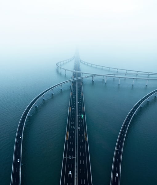 Interconnected bridges over water under misty sky