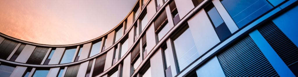 Ground-up view of office block at sunset