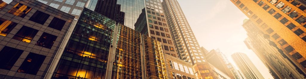 Ground-up view of glass office buildings on a sunny day