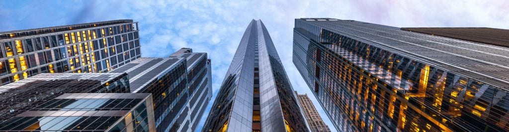 Ground-up view of glass office buildings on a cloudy day