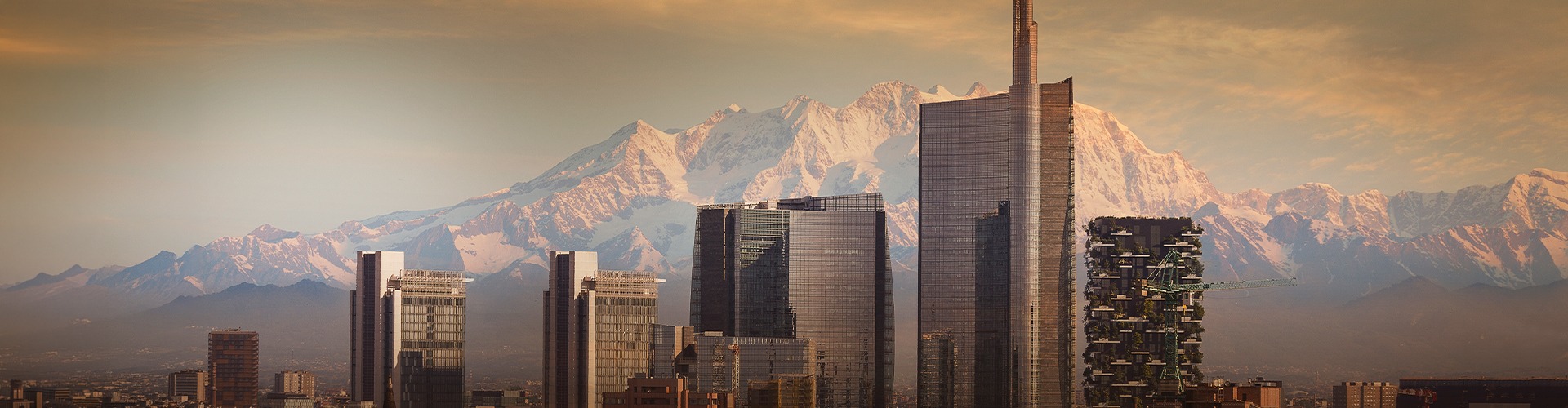 Modern skyline of Milan, Italy, with skyscrapers against mountain backdrop