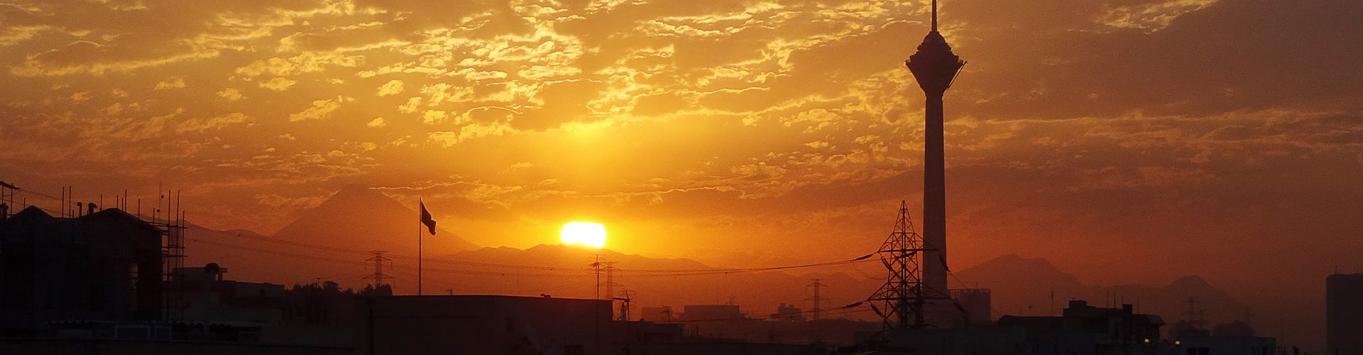 Bright orange sunrise/sunset over military industrial site