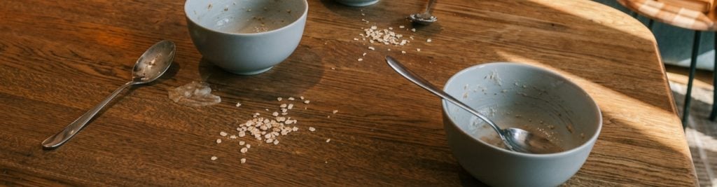 Two empty bowls of porridge oats on a wooden table