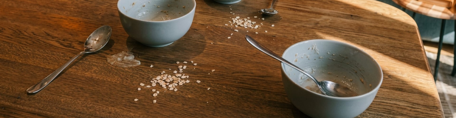 Two empty bowls of porridge oats on a wooden table