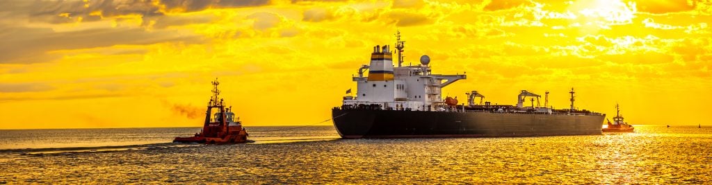 Oil tanker in the ocean against a yellow sunset background