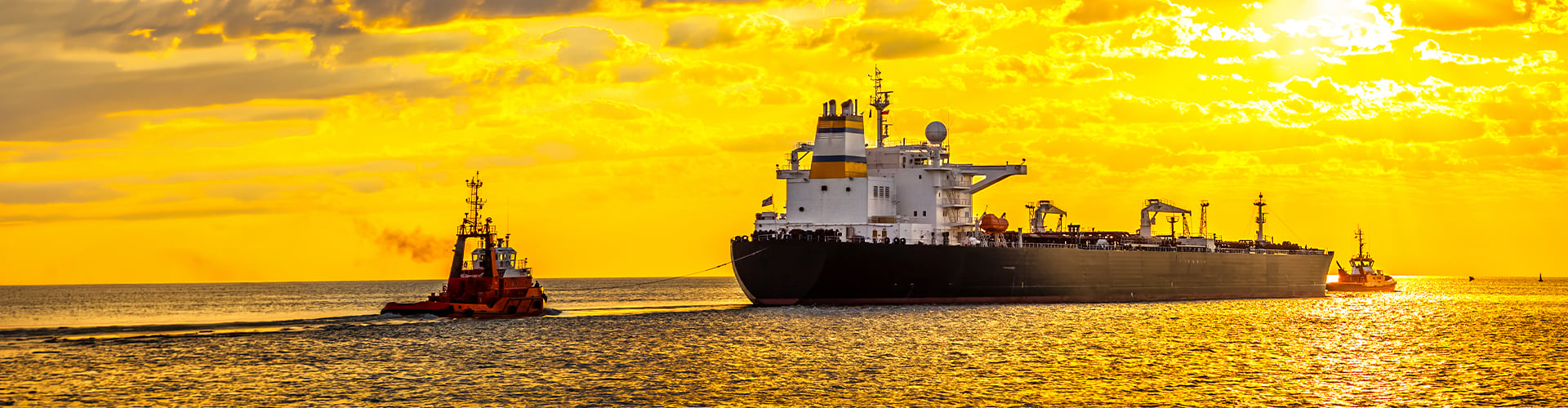 Oil tanker in the ocean against a yellow sunset background