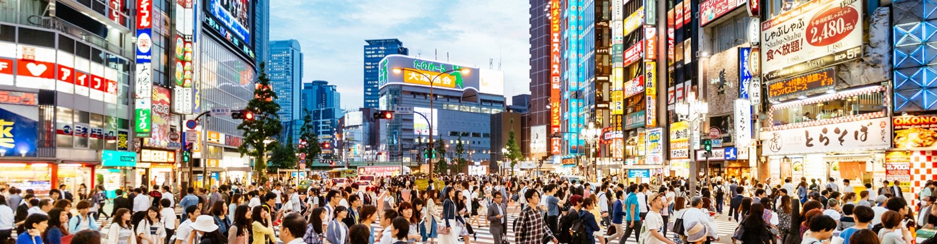 Busy city centre in Tokyo with bright neon signs and crowds of people