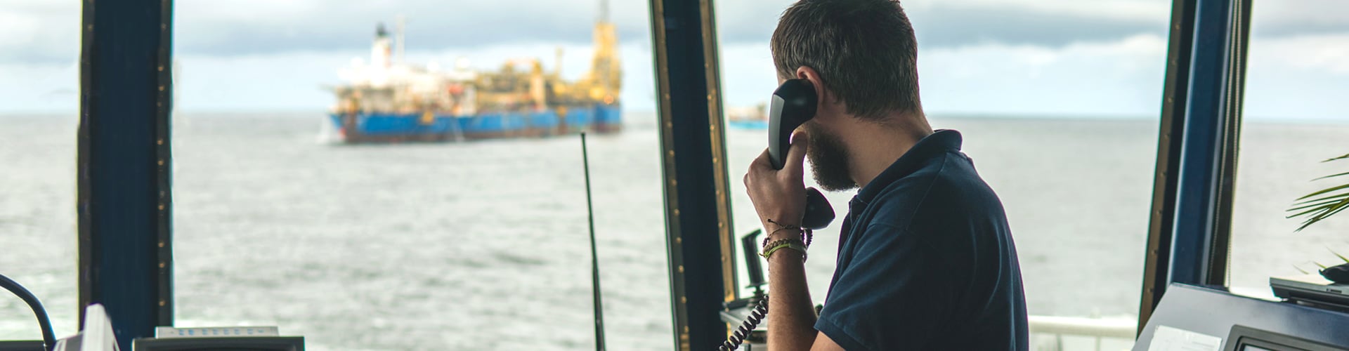 Person speaking on a telephone inside a ship or harbor control room