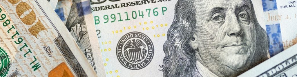 US dollar banknotes with Federal Reserve seal.