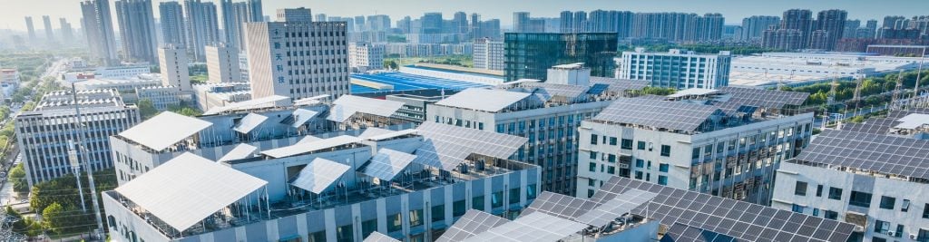 Aerial view over real estate with solar panels on roofs