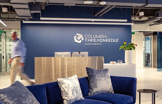 Reception area at Columbia Threadneedle Investments' London office with company branding behind the front desk and seating area in the foreground.
